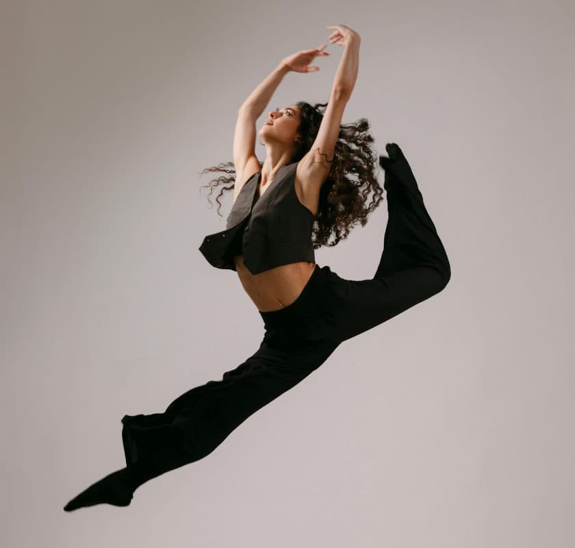 A dancer mid-leap, arms raised